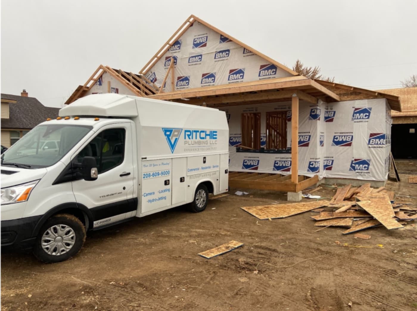 Ritchie Plumbing service van parked at a home under framing